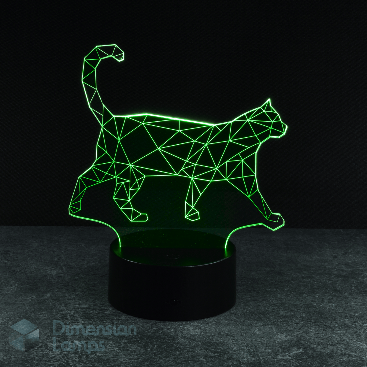 A 3D lamp displays a green illuminated geometric wireframe of a cat in a walking pose, rising from a black base against a dark background. This unique 3d night lamps option makes a thoughtful gift idea for cat lovers.