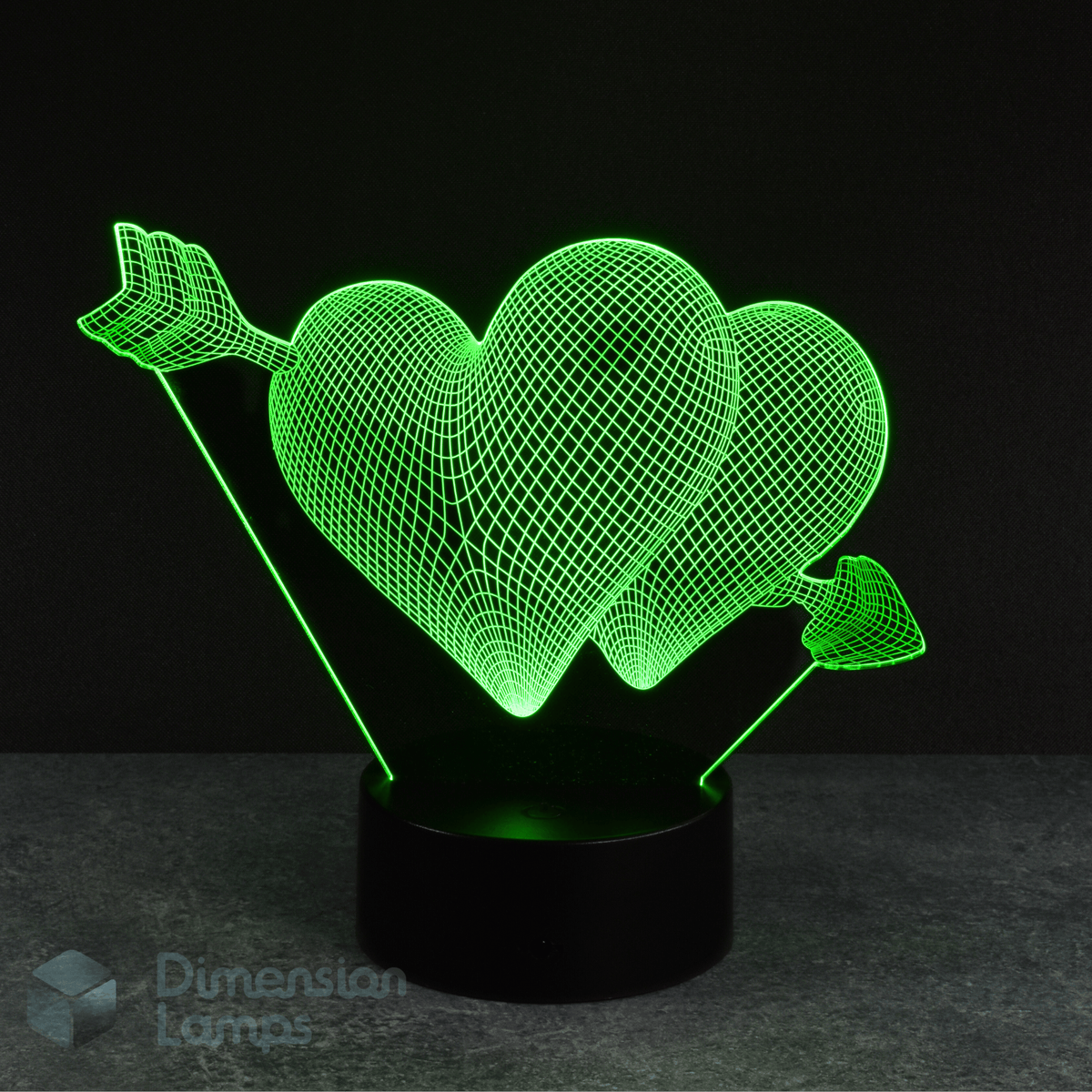 Green hearts and arrow 3d night lamps: a love-themed design featuring two hearts pierced by an arrow, illuminated by green LEDs on a base against a dark background. A unique lighting solution for a girl's room. 