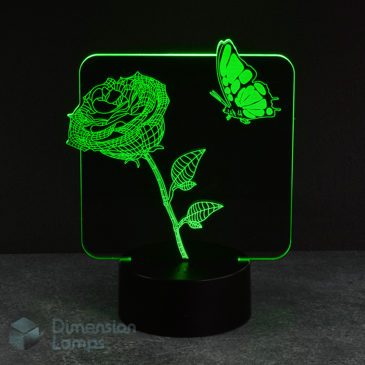 A green LED light forms the shape of a rose flower on a stem with leaves and a butterfly in this 3D lamp, set against a dark backdrop. This floral and butterfly lamp offers a unique and eye-catching lighting option.