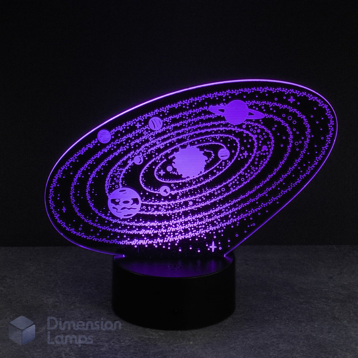 An illuminated purple 3D representation of the solar system, with etched planets orbiting the sun, displayed on a black base against a dark backdrop. This Solar System 3d night lamp is a unique addition to a boys room.