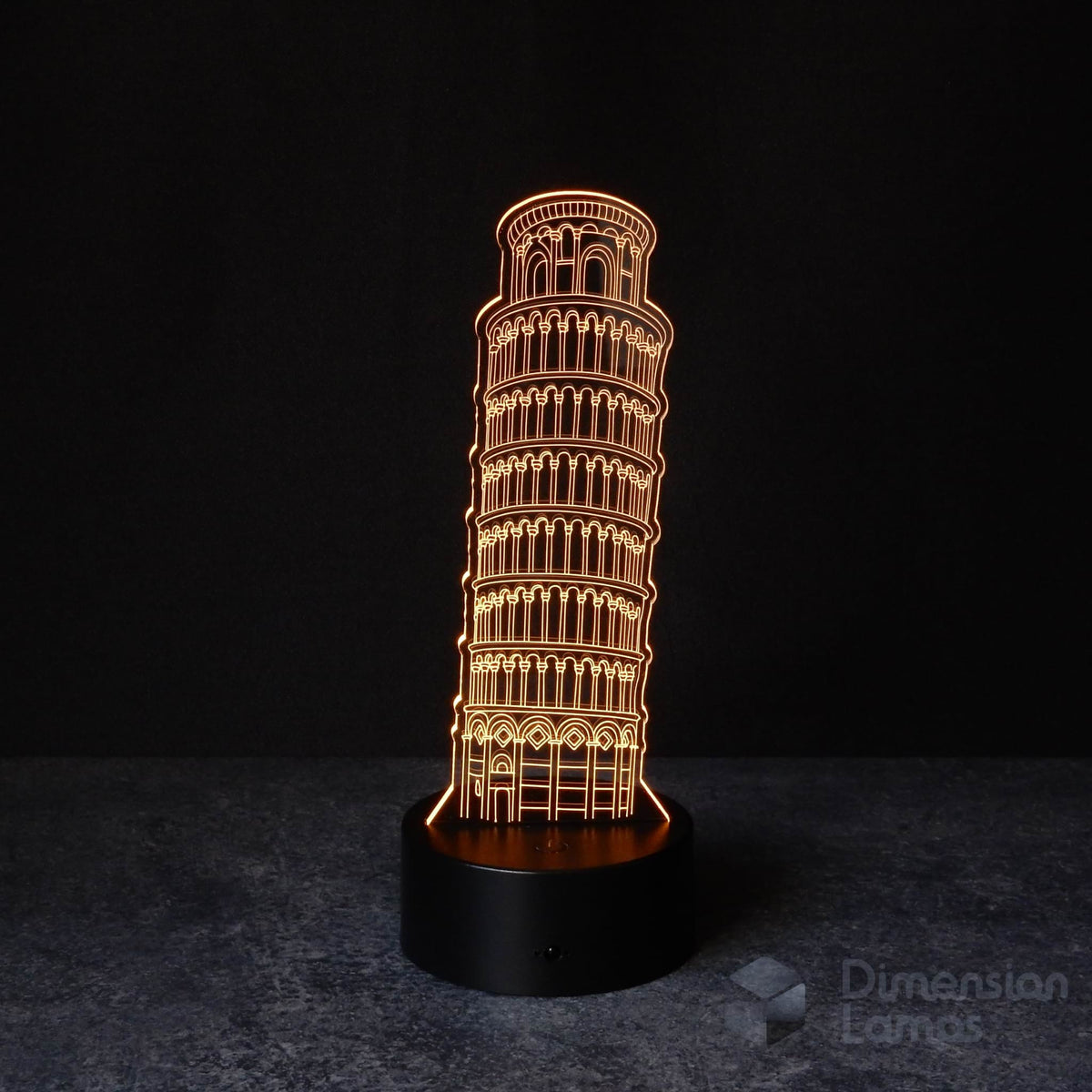 A 3D illusion lamp of the Leaning Tower of Pisa, emitting a warm amber light. A nostalgic travel memento of italy and unique home decor piece.