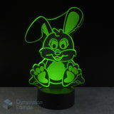 An LED 3D lamp of a cartoon bunny, glowing bright green against a black background. A Dimension Lamps watermark is visible in the bottom-left corner.