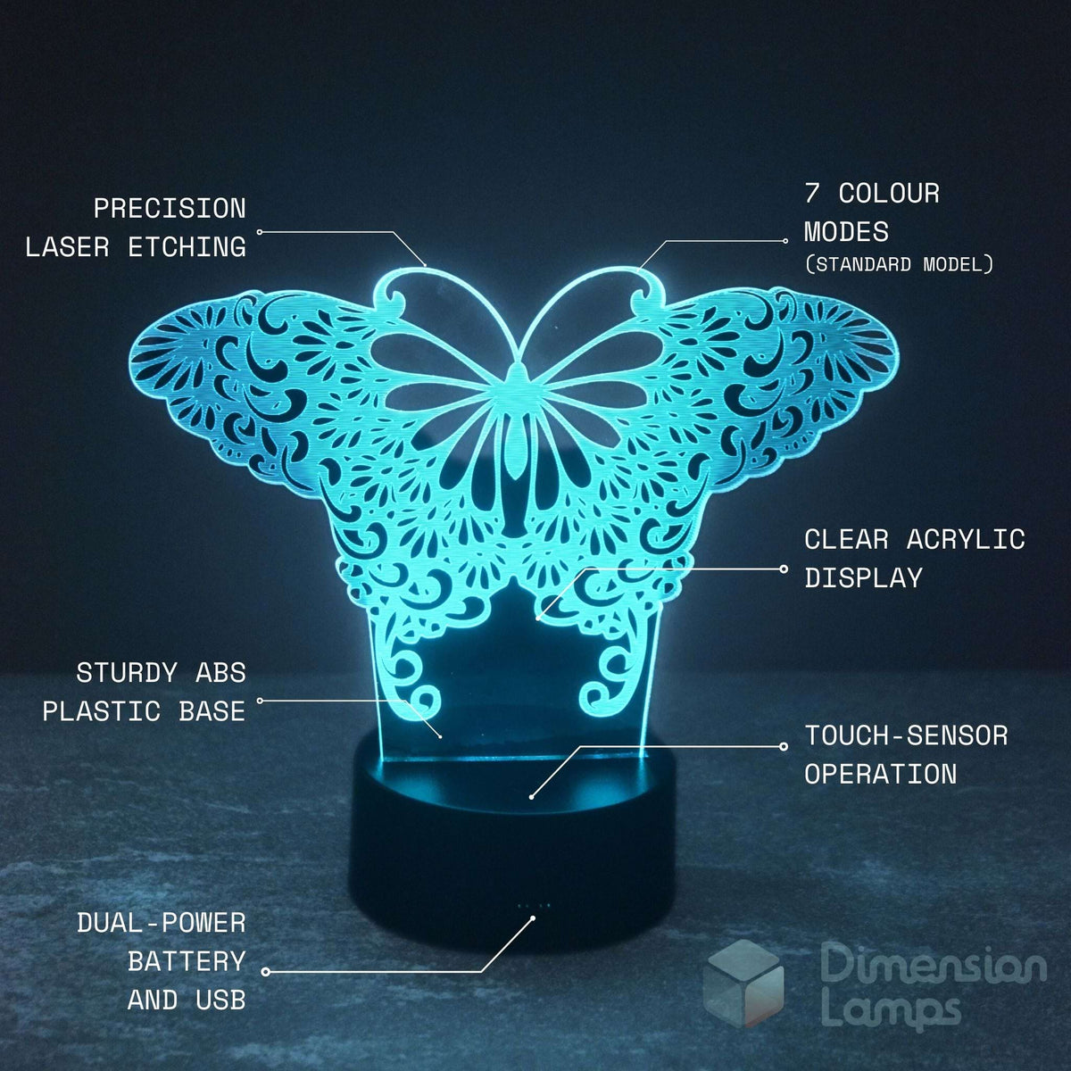 A butterfly-shaped LED night light with laser-cut ornamental patterns on a black cylindrical base, shown glowing in cyan-blue light against a dark background. White text callouts label features such as precision laser etching, 7 colour modes, clear acrylic display, sturdy ABS plastic base, touch-sensor operation, and dual-power battery and USB.