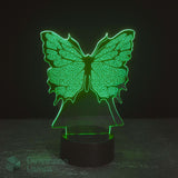 A 3D optical illusion lamp shaped like a butterfly, glowing with a bright green light from a black cylindrical base, set against a dark background. Girls night light.