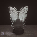 A butterfly-shaped LED night light with intricate wing patterns, glowing with a white light on a black cylindrical base, set against a dark background.