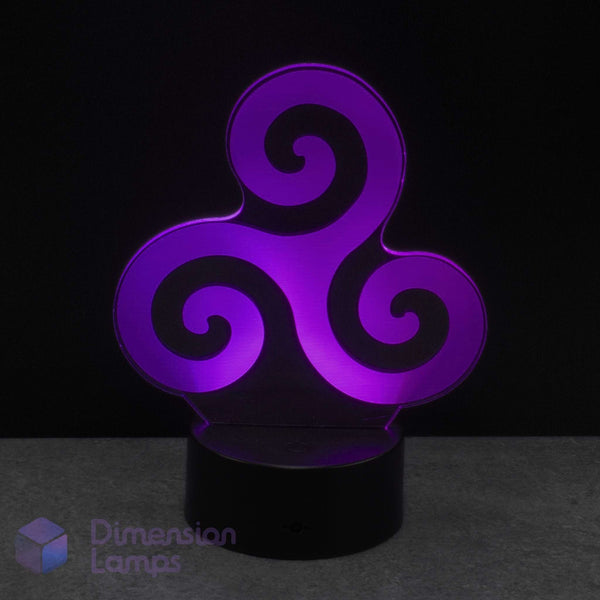 A 3D optical illusion night light featuring a glowing purple Celtic triskelion symbol on a black base, set against a dark background. Representing natural elements; earth, water, and sky.