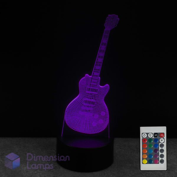 A 3D optical illusion lamp shaped like an electric guitar, glowing with a purple light on a black base, shown with a white remote control against a black background. Guitarist gift idea. 