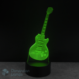 Guitar-shaped lamp emitting a green light. Lucille themed guitar gift idea.  