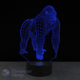 A 3D optical illusion lamp shaped like a gorilla, glowing blue wireframe effect on a black base against a dark background with a Dimension Lamps logo.