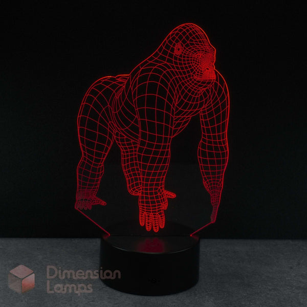 A 3D optical illusion night light shaped like a gorilla, glowing with red LED lines on a black circular base against a dark background.