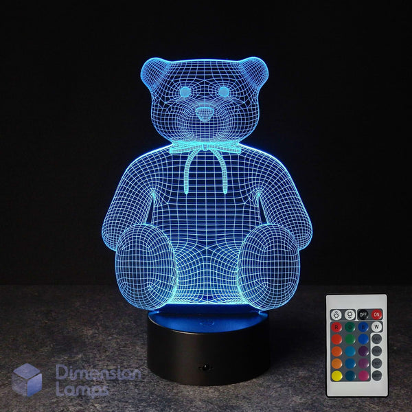 Cyan illuminated 3D wireframe teddy bear lamp with a 16 colour remote control on a dark background