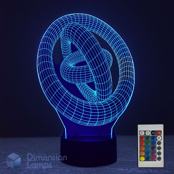 A 3D optical illusion lamp shaped like a stylized knot, glowing with a bright blue light, shown with its remote control on a dark background. The brand 'Dimension Lamps' is visible as a watermark in the bottom-left corner.