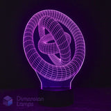 A 3D optical illusion LED night light depicting a glowing purple knot, set against a dark background with a Dimension Lamps in the lower-left corner.