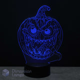 A glowing blue 3D optical illusion lamp of a spooky jack-o'-lantern face, on a black base, with a Dimension Lamps logo in the lower-left corner.