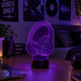 A 3D LED night light of over-ear headphones, glowing purple wireframe on a wooden desk in a bedroom setting. Gift for teens into listening to music.