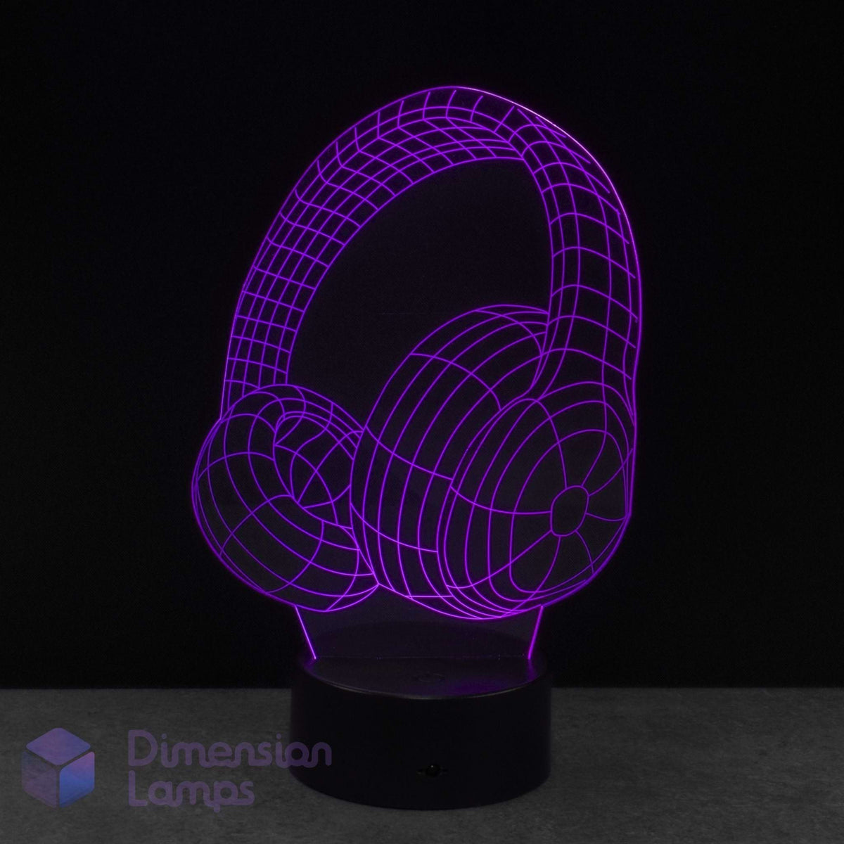 A 3D optical illusion LED lamp shaped like over-ear headphones, glowing with a purple wireframe effect on a black base against a dark background.