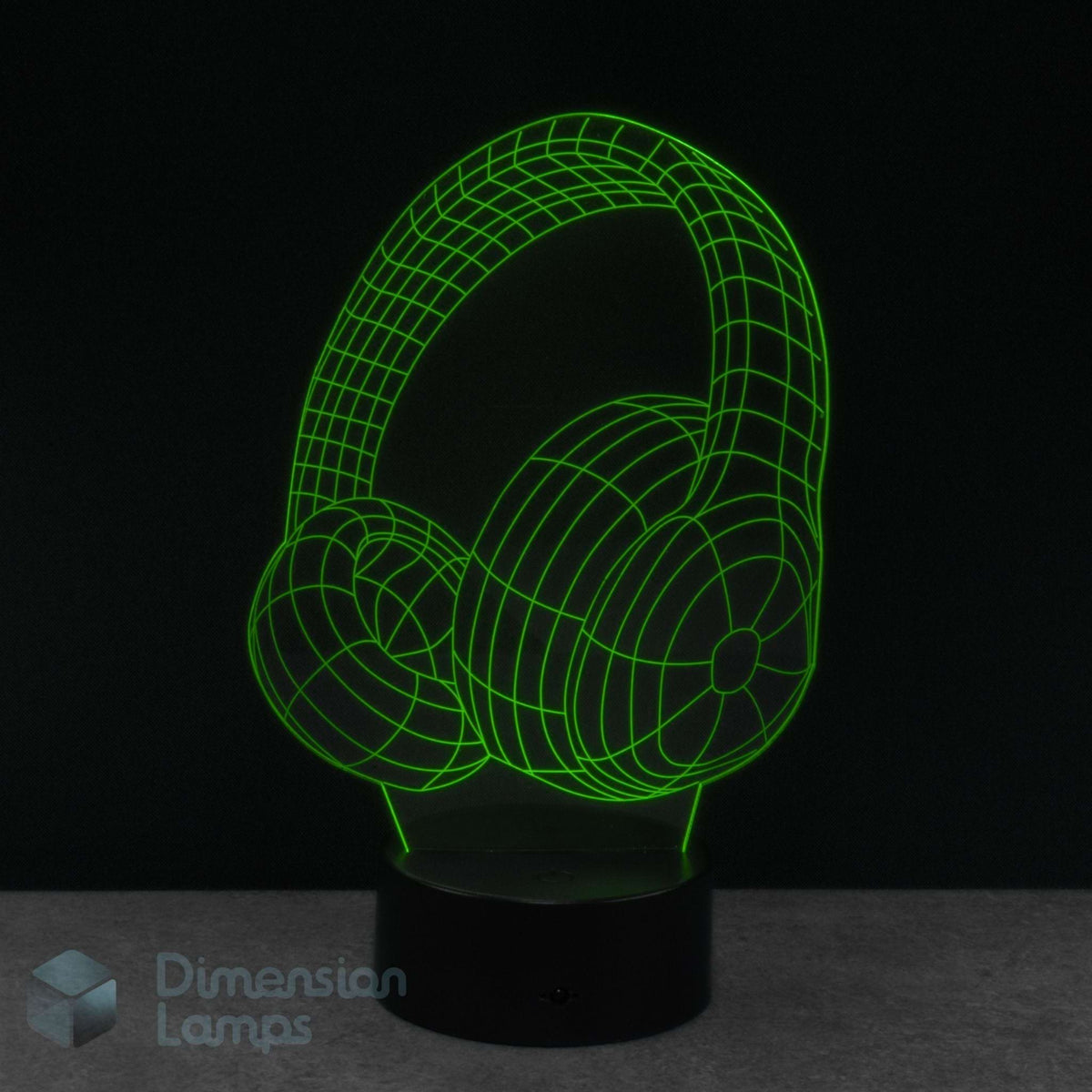 A 3D optical illusion night light of headphones, glowing bright green wireframe lines on a black base. Perfect gift for teens that listen to music. 