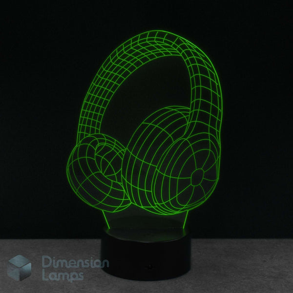 A 3D optical illusion night light of headphones, glowing bright green wireframe lines on a black base. Perfect gift for teens that listen to music. 
