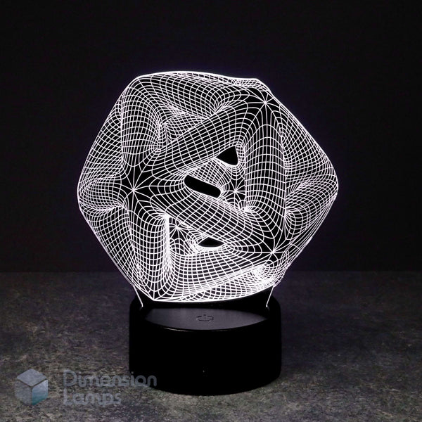 A 3D optical illusion lamp featuring a white wireframe icosahedron geometric design that creates a swirling, abstract effect, resting on a black cylindrical base against a dark background.