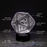 A 3D illusion lamp with a glowing white geometric wireframe design on a black base, with text labels describing its features.