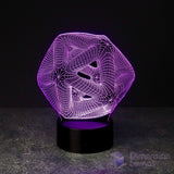 A 3D optical illusion LED lamp with a purple glowing geometric icosahedron design on a black cylindrical base, set against a dark background.