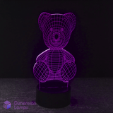 A purple illuminated Teddy Bear 3D LED lamp on a dark background, depicting a seated teddy bear figure.