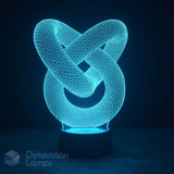 A 3D optical illusion LED night light shaped like an interlocking knot, glowing with a bright cyan-blue light on a dark base against a dark background. A 'Dimension Lamps' logo watermark is visible in the bottom-left corner.