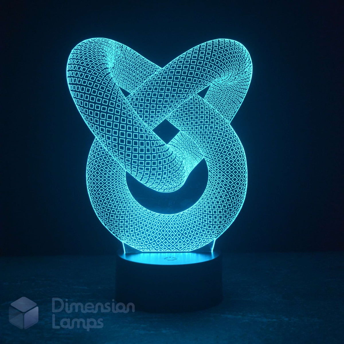 A 3D optical illusion LED night light shaped like an interlocking knot, glowing with a bright cyan-blue light on a dark base against a dark background. A 'Dimension Lamps' logo watermark is visible in the bottom-left corner.