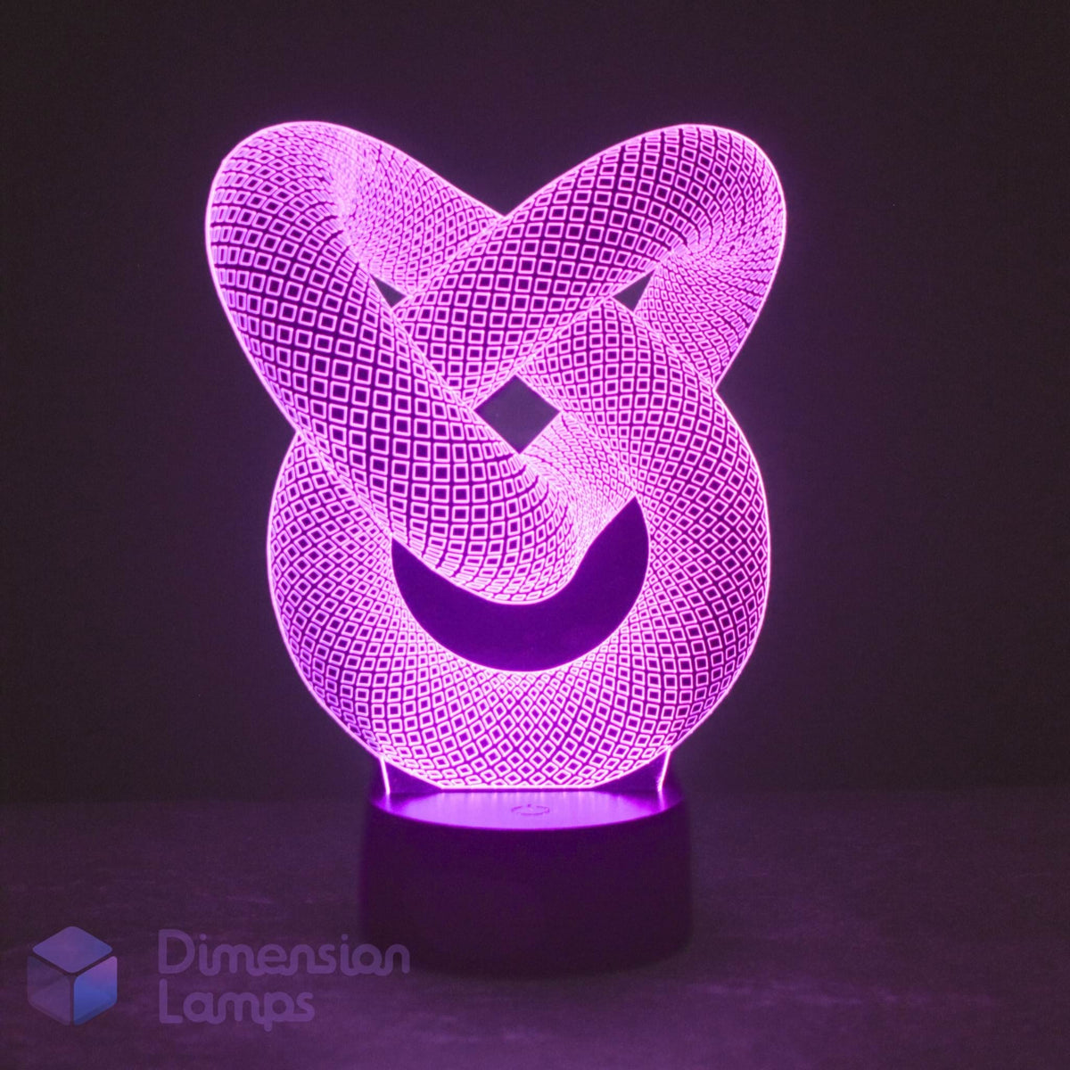 A 3D optical illusion LED night light shaped like an interwoven knot, glowing with a vibrant purple light on a dark base. The brand name 'Dimension Lamps' is visible as a watermark in the bottom-left corner.