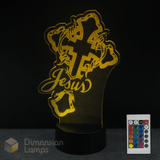 LED lamp with 'Jesus' text on a cross with crown of thorns and remote control on a dark background.