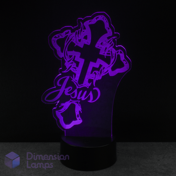 Purple cross-shaped LED lamp with 'Jesus' text on a black background.  Catholic teen gift idea.