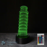 A 3D LED illusion lamp depicting the Leaning Tower of Pisa, glowing bright green on a black base, shown with a 16 colour remote control on a dark background.