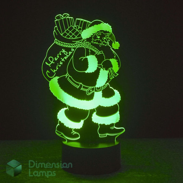 A glowing green 3D LED lamp of Santa Claus carrying a Christmas sack, on a dark background with a 'Dimension Lamps' logo in the lower-left corner.