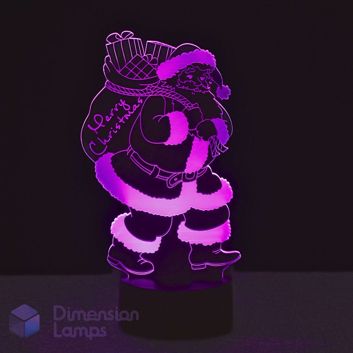 A 3D LED night light of Santa Claus carrying a gift sack with 'Merry Christmas' written on it, glowing purple light against a black background. 