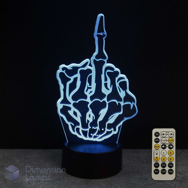 A 3D optical illusion night light shaped like a skeletal hand showing the middle finger, illuminated in blue light on a black base, with a 7 colour sleep timer remote control shown to the right against a dark background.