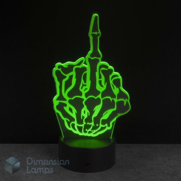 A 3D optical illusion LED night light shaped like a skeleton hand making the middle finger, glowing bright green on a black base against a dark background. Novelty young adult fun gift idea. 