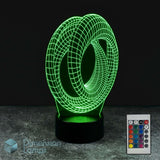 A 3D optical illusion LED night light of a mobius strip scientific gift idea, glowing green on a black base, shown with a remote control and a 'Dimension Lamps' logo watermark against a dark background.