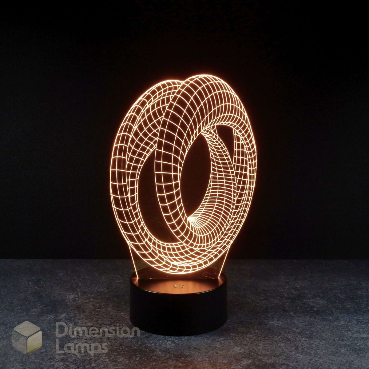 Mobius strip 3d night lamps: yellow illumination of a continuous looped geometric design on a lamp, rising from a base against a dark background. Marvel Avengers Endgame movie.