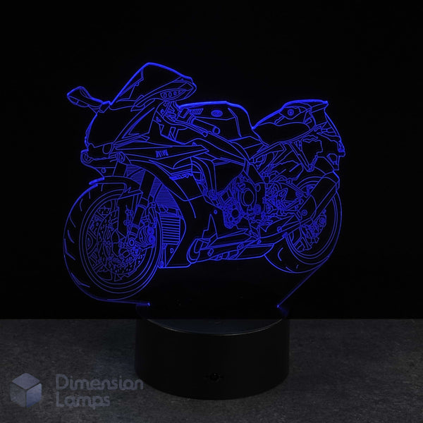 Motorcycle-shaped night light emitting a blue glow on a black background. Gift idea for supersport Motorbike fans.