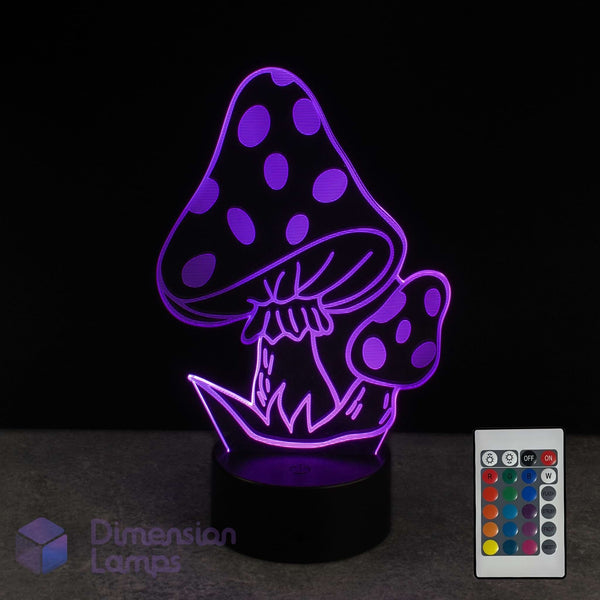 A 3D optical illusion LED night light shaped like mushrooms, glowing with purple light on a black base, shown next to its 16 colour remote control against a black background.