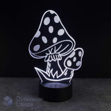 A 3D optical illusion night light shaped like two spotted mushrooms, glowing with white light on a black base against a dark background. A 'Dimension Lamps' watermark is visible in the bottom-left corner.