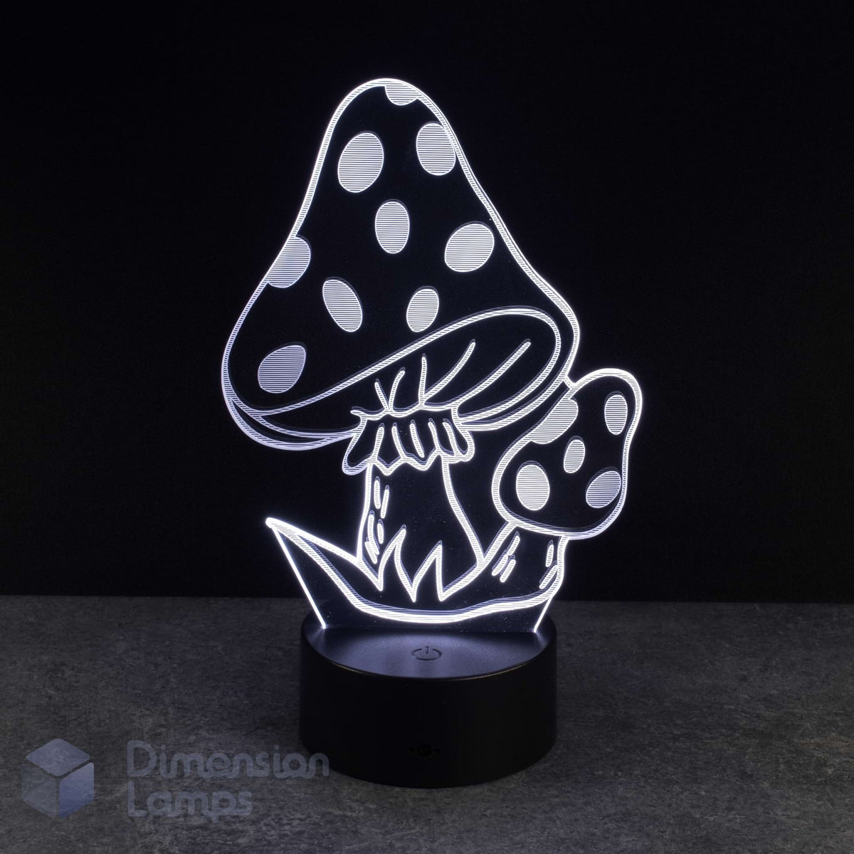 A 3D optical illusion night light shaped like two spotted mushrooms, glowing with white light on a black base against a dark background. A 'Dimension Lamps' watermark is visible in the bottom-left corner.