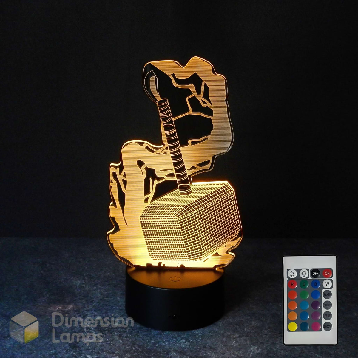A 3D optical illusion night light shaped like Thor's hammer (Mjolnir) on a black base, shown illuminated against a dark background with a 16 colour remote control and a 'Dimension Lamps' logo overlay.
