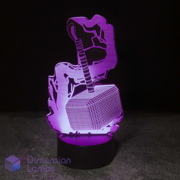 A 3D optical illusion night light featuring Thor's hammer (Mjolnfr) resting on a lightning-bolt base, glowing with purple and pink light against a dark background. A 'Dimension Lamps' logo is visible in the bottom-left corner.
