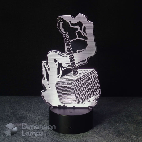 A 3D optical illusion LED night light depicting Thor holding his hammer Mjolnir, illuminated on a black circular base against a dark background. A watermark for 'Dimension Lamps' is visible in the bottom-left corner.