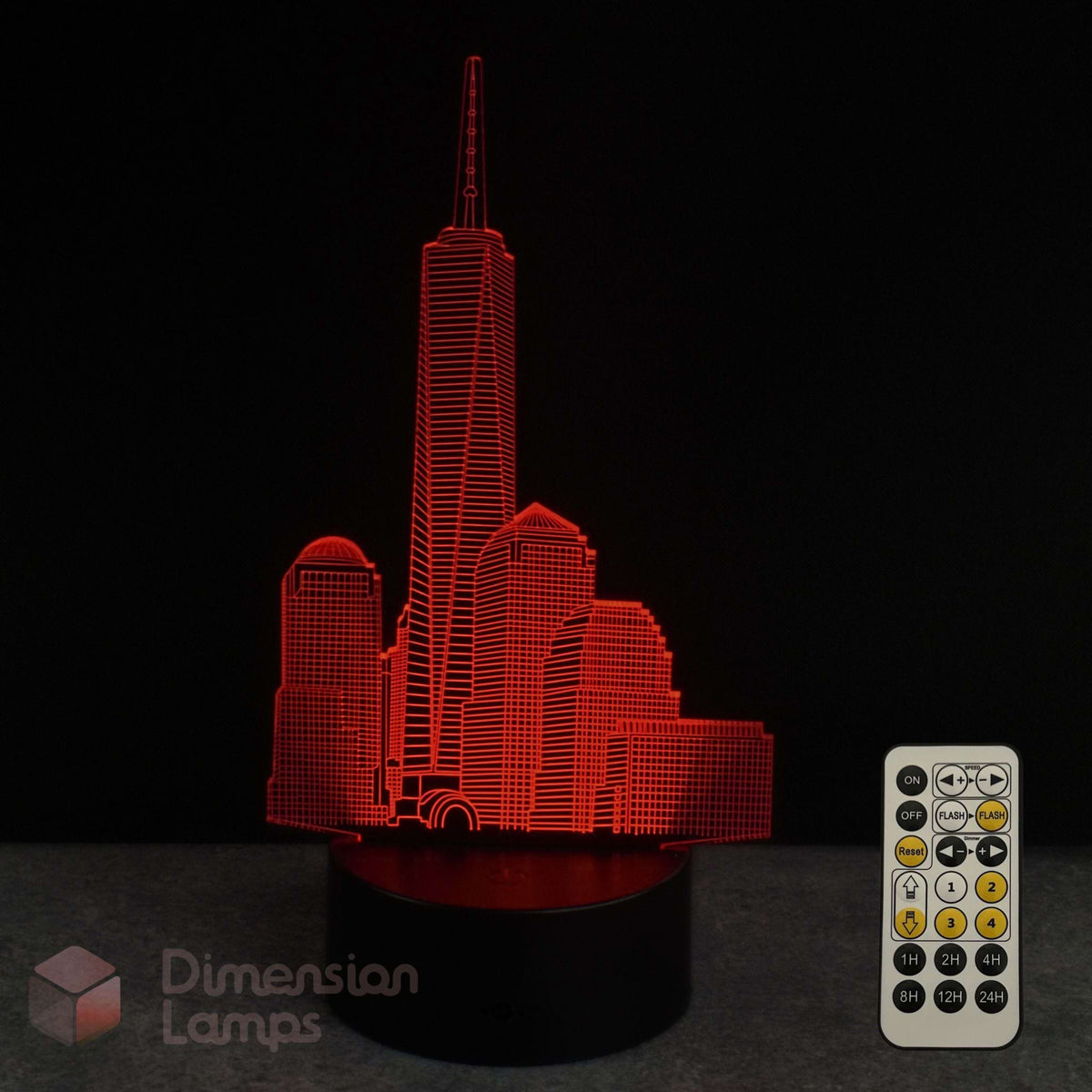 Red LED light-up cityscape lamp featuring the One World Trade Center  on a black base, shown with a white remote control against a dark background. A 'Dimension Lamps' logo watermark is visible in the lower-left corner.