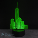 Green 3D One World Trade Center cityscape lamp on a black background with 'Dimension Lamps' branding.