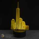 Yellow 3D One World Trade Center cityscape lamp on a black background with 'Dimension Lamps' branding.
