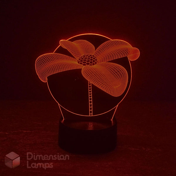 A 3D optical illusion LED lamp shaped like a flower, glowing with a warm red light on a dark base against a black background. A 'Dimension Lamps' watermark is visible in the lower-left corner.