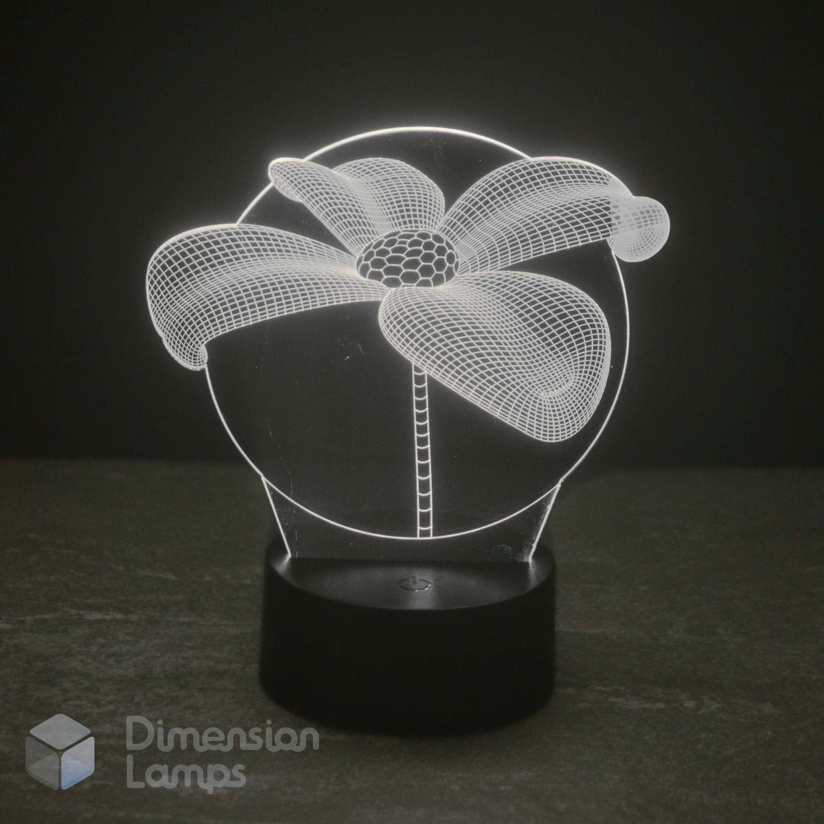 A 3D optical illusion lamp depicting a daisy flower, glowing with white light from a black cylindrical base on a dark grey surface against a black background. Aussie 'Dimension Lamps' watermark is visible in the bottom-left corner.